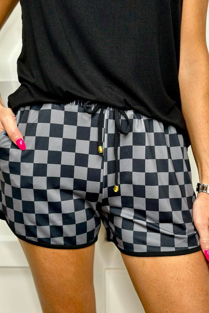mid-rise, tie waist drawstring, side pockets, & relaxed fit on a black checkered print