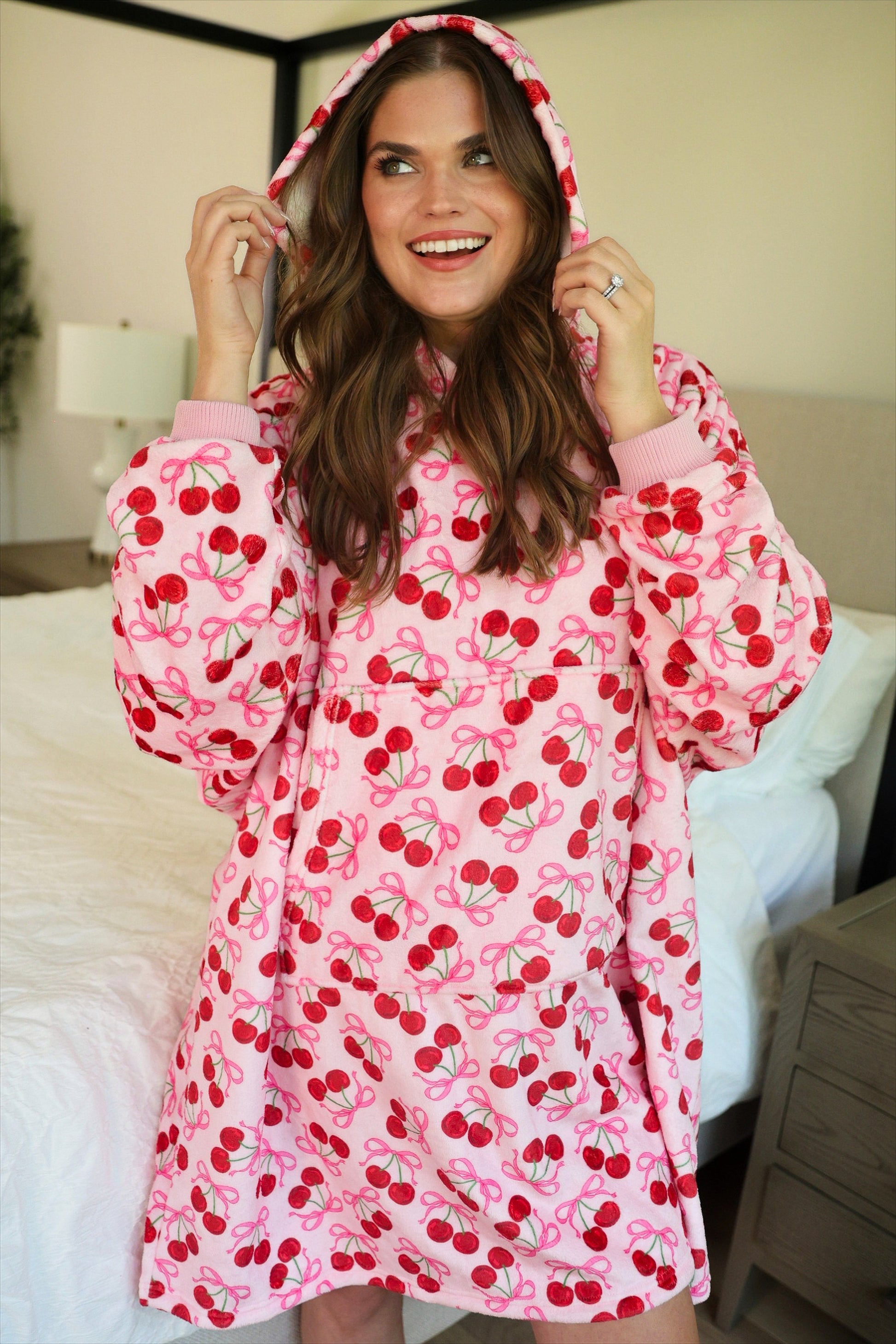 a blanket hoodie with roomy long sleeves finished with soft ribbed cuffs, a slouchy hood, drop shoulder, a kangaroo pouch on ultra plush fabric in Cherry Bomb (Pink)