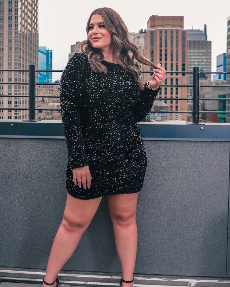 a black long-sleeve dress with shimmering allover sequins detailing, a flattering silhouette, a soft-lined interior, and a back zipper that extends two-thirds down for a polished, easy fit