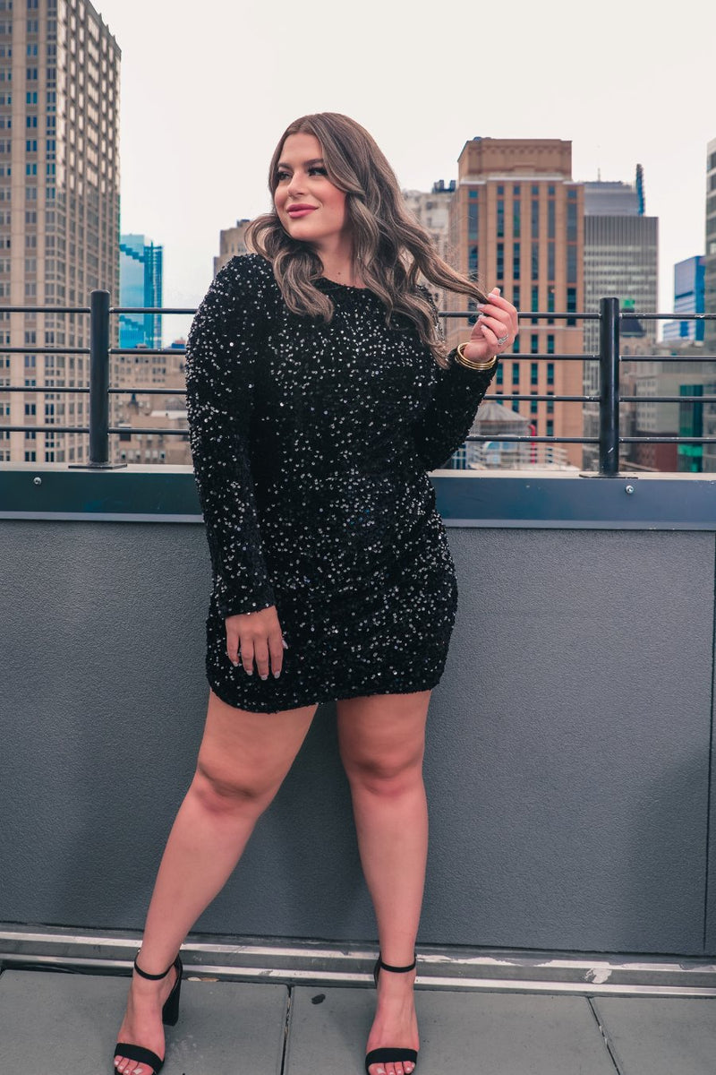 a black long-sleeve dress with shimmering allover sequins detailing, a flattering silhouette, a soft-lined interior, and a back zipper that extends two-thirds down for a polished, easy fit