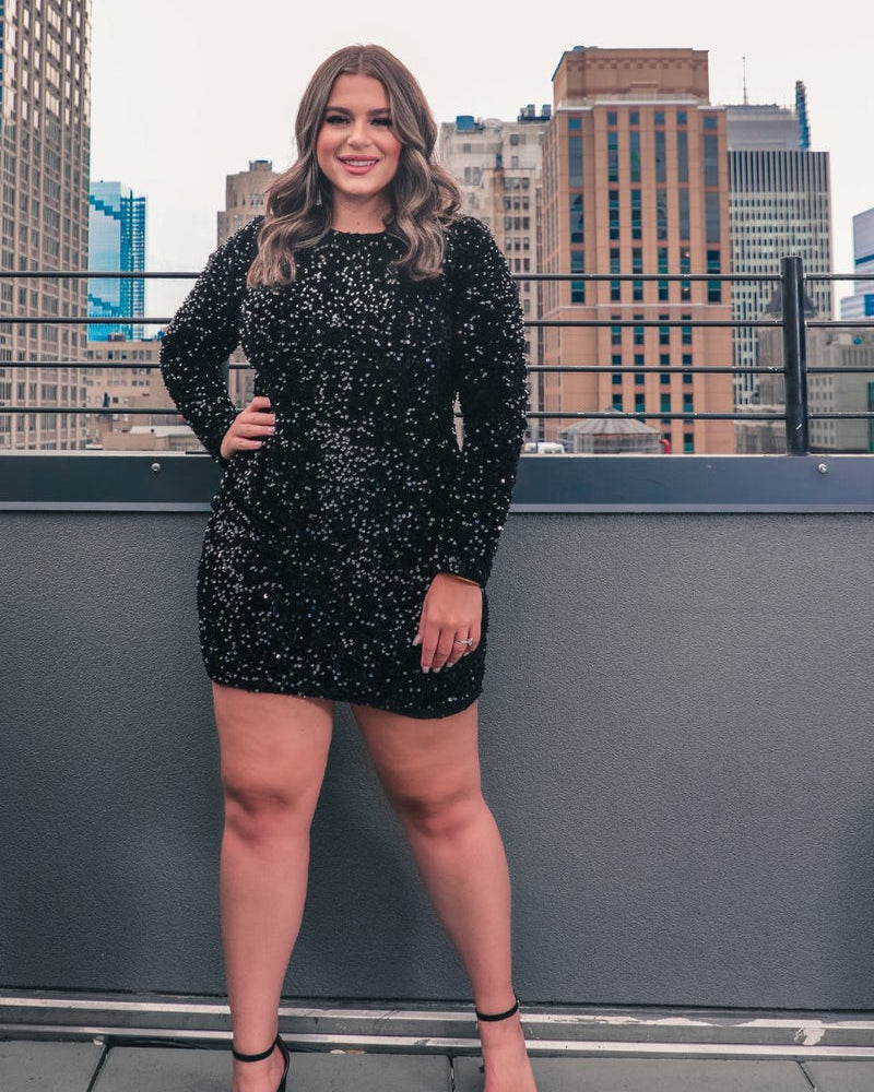 a black long-sleeve dress with shimmering allover sequins detailing, a flattering silhouette, a soft-lined interior, and a back zipper that extends two-thirds down for a polished, easy fit
