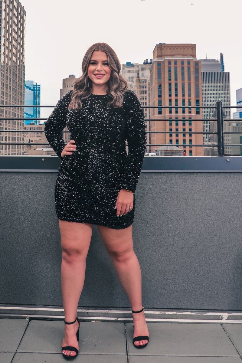 a black long-sleeve dress with shimmering allover sequins detailing, a flattering silhouette, a soft-lined interior, and a back zipper that extends two-thirds down for a polished, easy fit