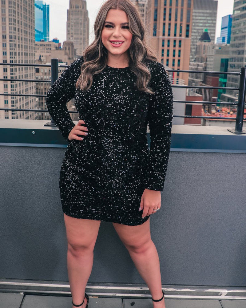 a long-sleeve dress with shimmering allover sequins detailing, a flattering silhouette, a soft-lined interior, and a back zipper that extends two-thirds down for a polished, easy fit in black