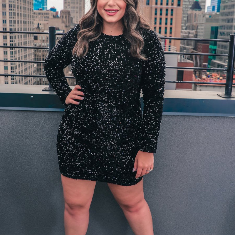 a long-sleeve dress with shimmering allover sequins detailing, a flattering silhouette, a soft-lined interior, and a back zipper that extends two-thirds down for a polished, easy fit in black