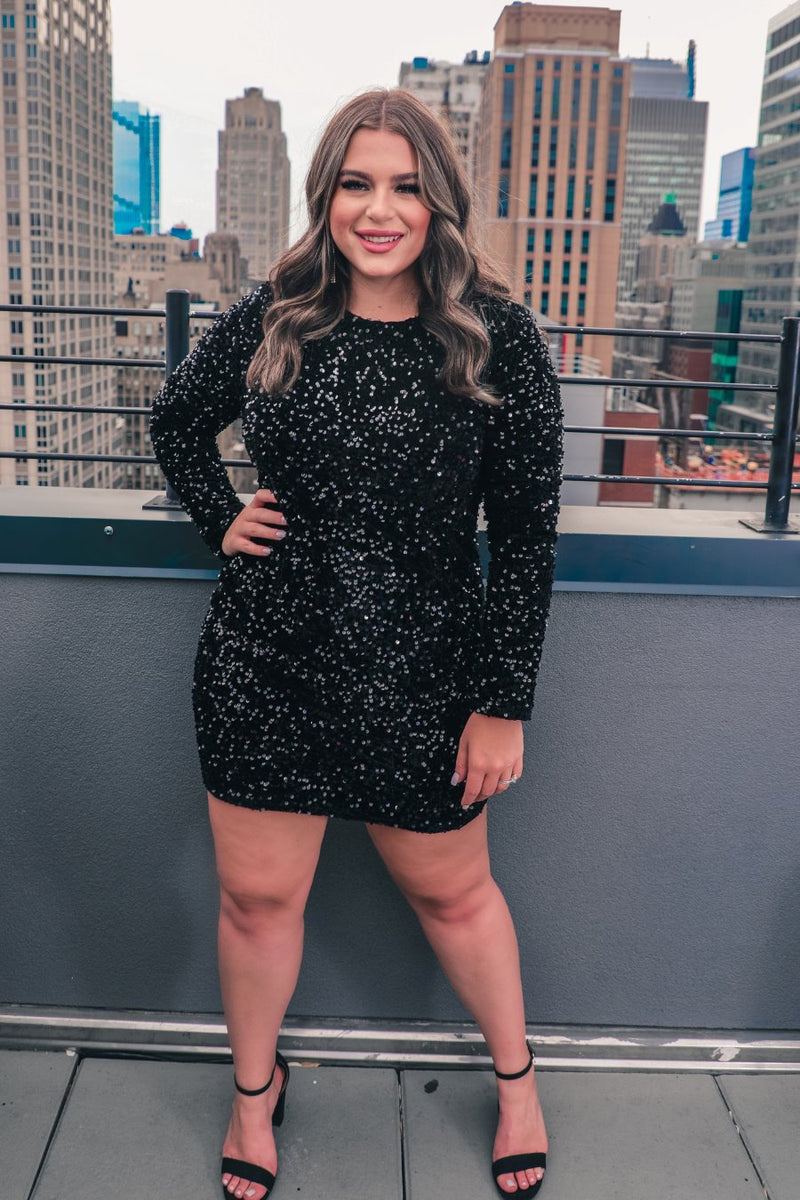 a long-sleeve dress with shimmering allover sequins detailing, a flattering silhouette, a soft-lined interior, and a back zipper that extends two-thirds down for a polished, easy fit in black