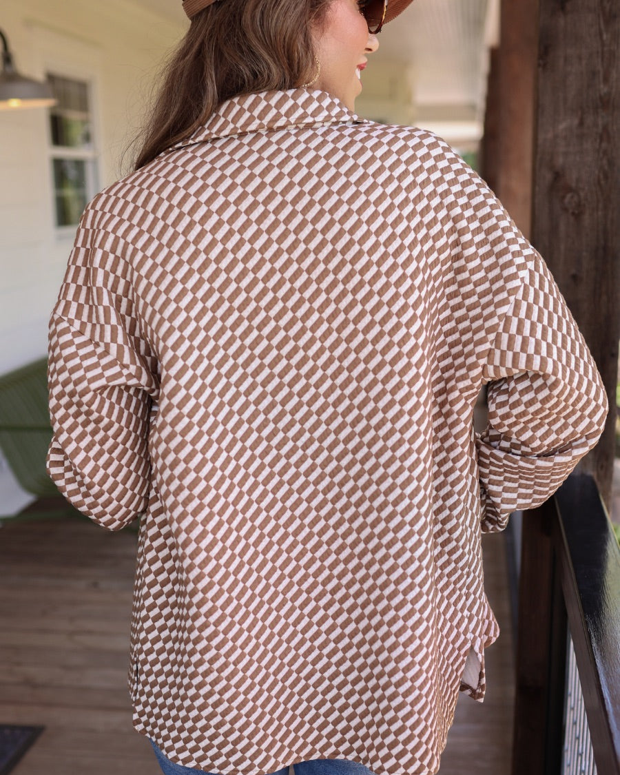 long-sleeve shacket with a foldable collar, button-up open front, and two chest pockets on a tan and white textured fabric