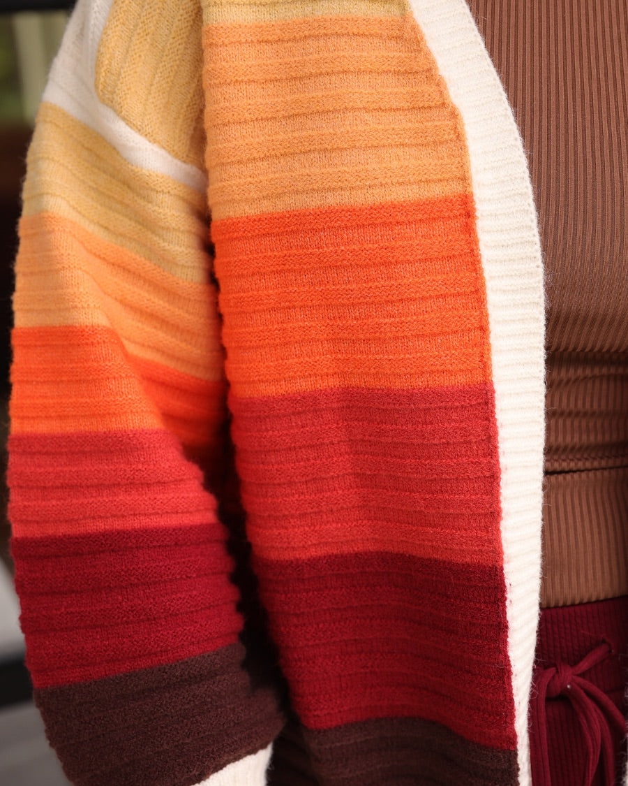 long-sleeve open front cardigan, finished in a vibrant ombré of cream, gold, orange, and rust tones on a soft knit fabric