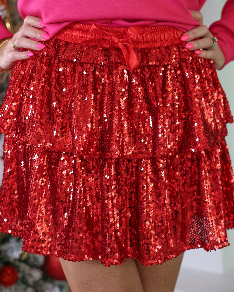 a tiered design skort with built-in shorts, an elastic waistband, and a drawstring tie on a red sequin fabric