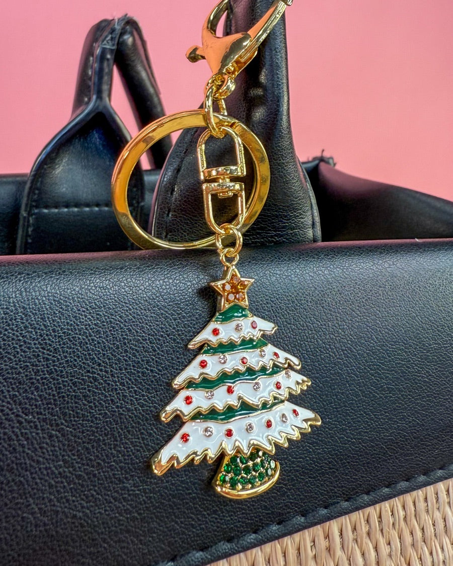 a festive layered green enamel fir Christmas tree with snowy white detailing, sprinkled with red and crystal accents, and crowned with a shimmering gold star, complete with a gold-tone swivel clasp and matching keyring