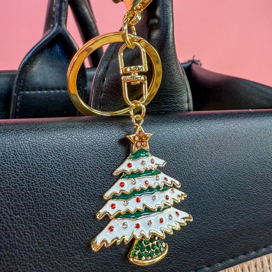 a festive layered green enamel fir Christmas tree with snowy white detailing, sprinkled with red and crystal accents, and crowned with a shimmering gold star, complete with a gold-tone swivel clasp and matching keyring