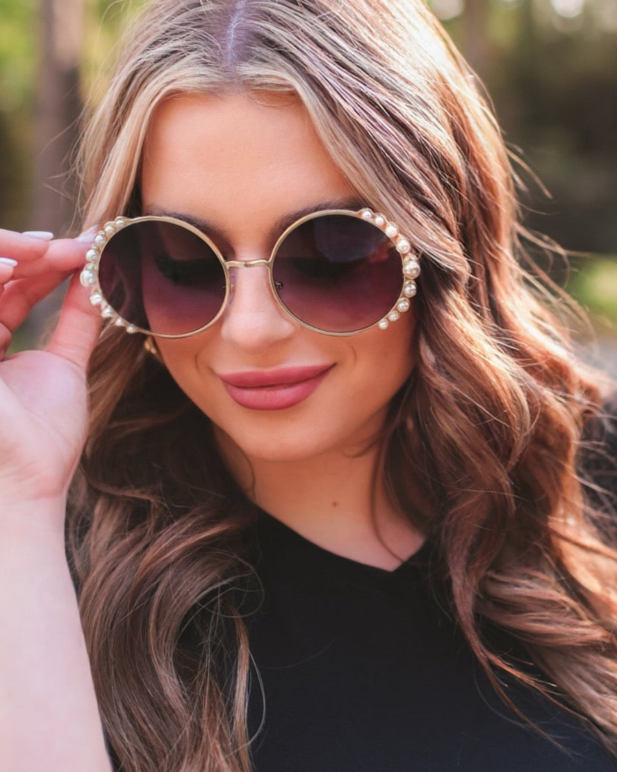 gold and black round sunglasses with scalloped edges and mixed-sized pearl trim around the frames, UV protection, and brand name detail (on both the temple and the complimentary black pouch)