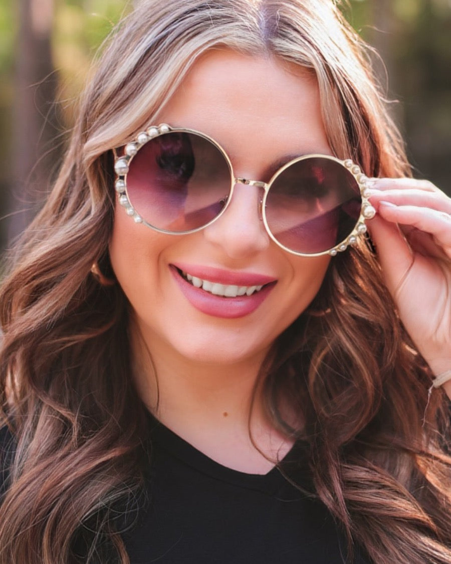 gold and black round sunglasses with scalloped edges and mixed-sized pearl trim around the frames, UV protection, and brand name detail (on both the temple and the complimentary black pouch)