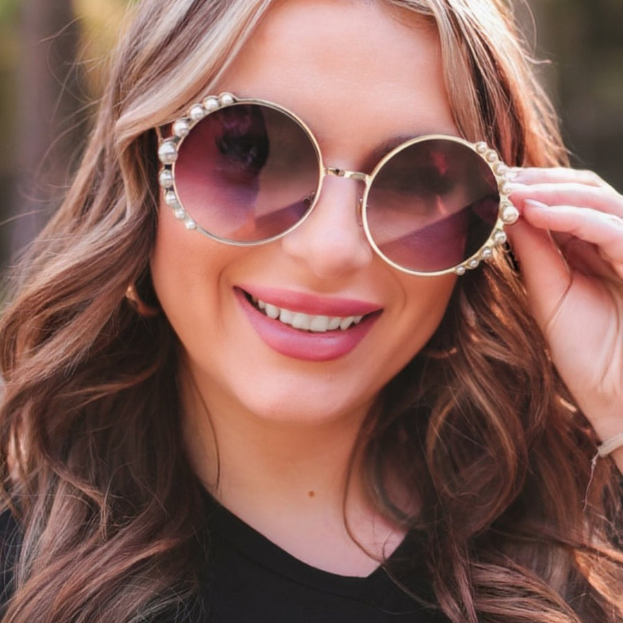 gold and black round sunglasses with scalloped edges and mixed-sized pearl trim around the frames, UV protection, and brand name detail (on both the temple and the complimentary black pouch)