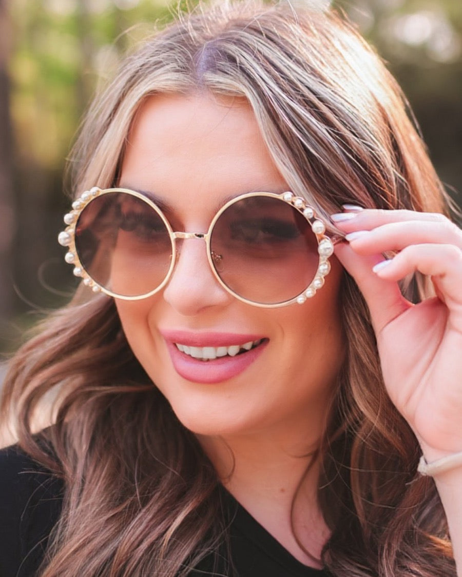 gold and brown round sunglasses with scalloped edges and mixed-sized pearl trim around the frames, UV protection, and brand name detail (on both the temple and the complimentary black pouch)
