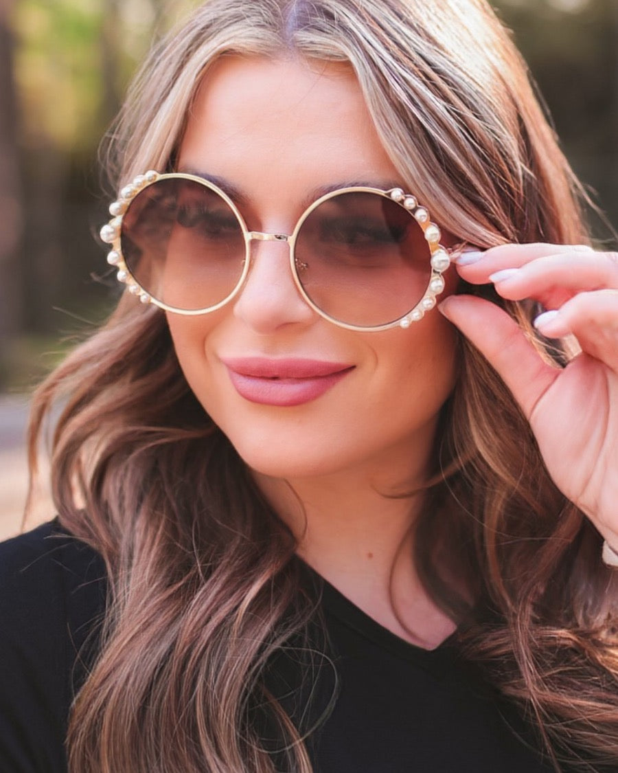 gold and brown round sunglasses with scalloped edges and mixed-sized pearl trim around the frames, UV protection, and brand name detail (on both the temple and the complimentary black pouch)