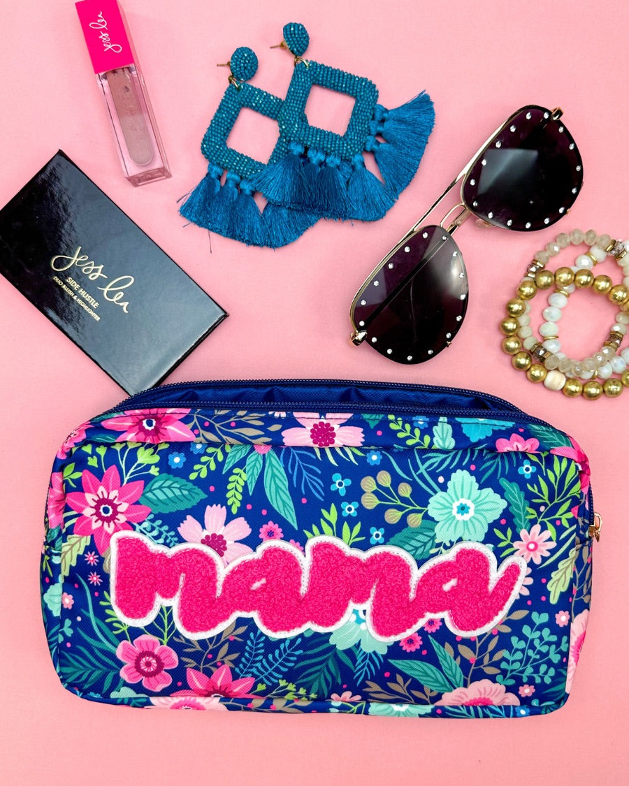 a lightweight spacious travel bag with a unique navy floral pattern (aqua, green, pink, and teal), a bold hot pink chenille 'mama' patch with white trim, and a zipper closer