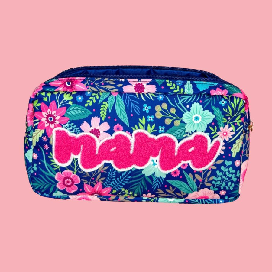 a lightweight spacious travel bag with a unique navy floral pattern (aqua, green, pink, and teal), a bold hot pink chenille 'mama' patch with white trim, and a zipper closer