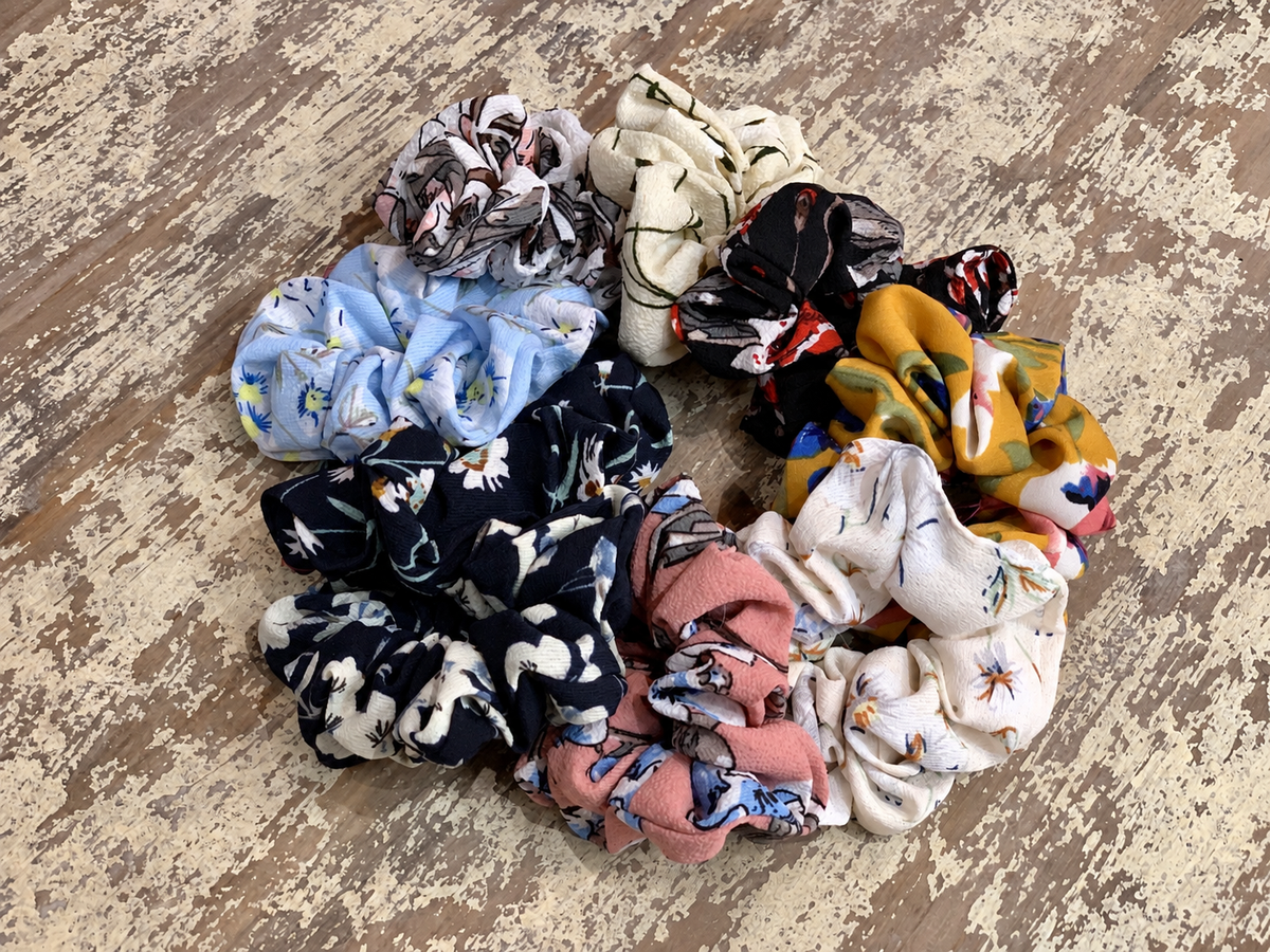 oversized floral scrunchies with lightweight textured fabric, gathered construction, gentle hair-friendly hold, and easy pull-on styling in banana, black, butterscotch, cream, mauve, navy cream, navy teal, sky, and white