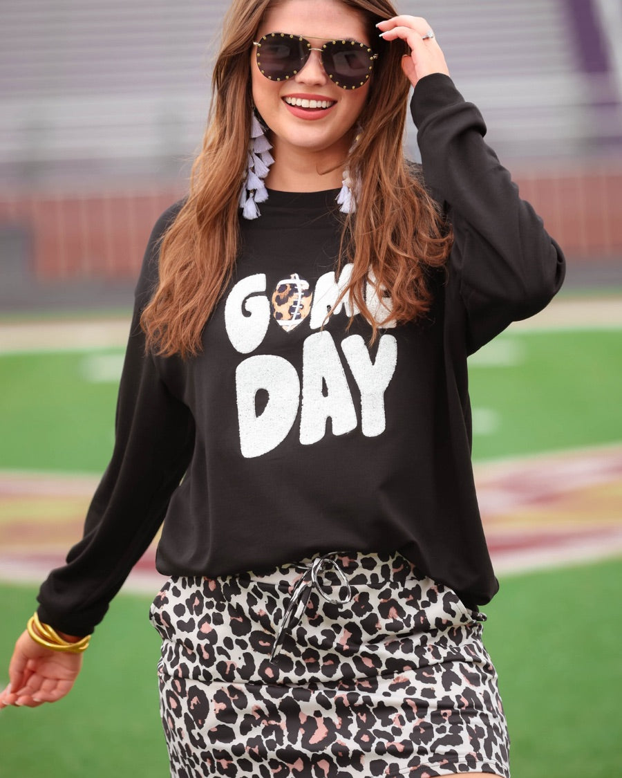 a black long-sleeve sweatshirt with standout "Game Day" chenille patch lettering in white and a leopard football detail as the A on an ultra-soft, midweight fabric