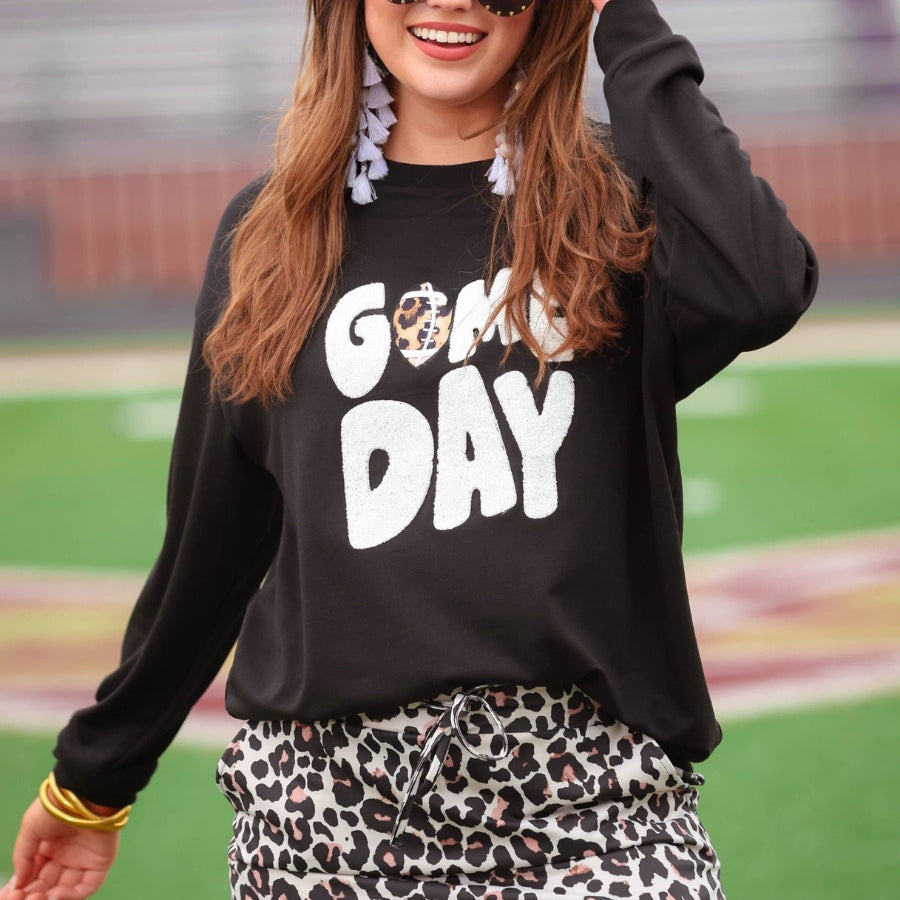 a black long-sleeve sweatshirt with standout "Game Day" chenille patch lettering in white and a leopard football detail as the A on an ultra-soft, midweight fabric
