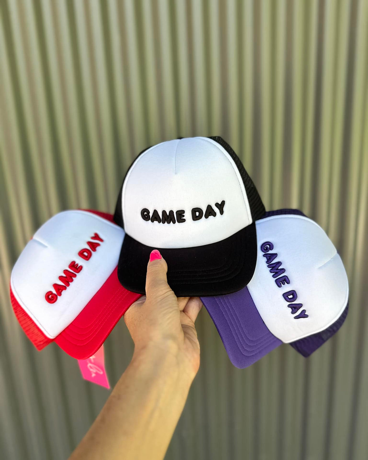 lightweight two-tone trucker hats with raised embroidered 'GAME DAY' lettering, tall foam front panel, breathable mesh back, snapback closure, and a curved bill in red, black, and purple