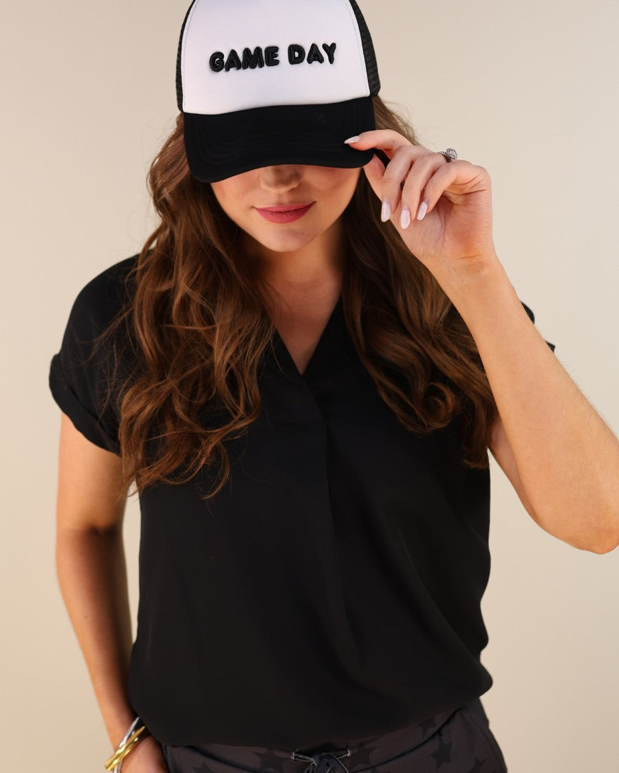 a lightweight black two-tone trucker hat with raised embroidered 'GAME DAY' lettering, tall foam front panel, breathable mesh back, snapback closure, and a curved bill