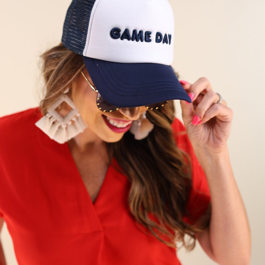 a lightweight navy two-tone trucker hat with raised embroidered 'GAME DAY' lettering, tall foam front panel, breathable mesh back, snapback closure, and a curved bill