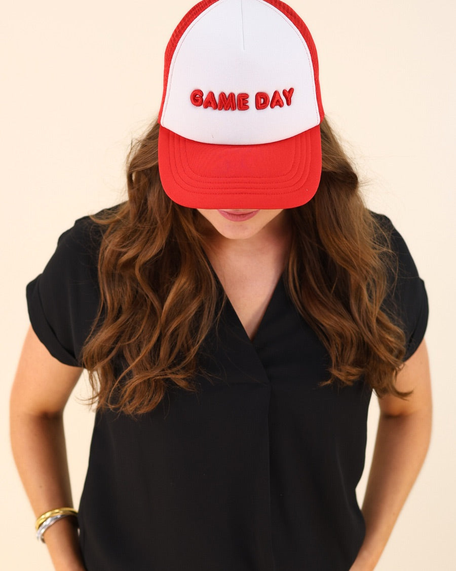a lightweight red two-tone trucker hat with raised embroidered 'GAME DAY' lettering, tall foam front panel, breathable mesh back, snapback closure, and a curved bill