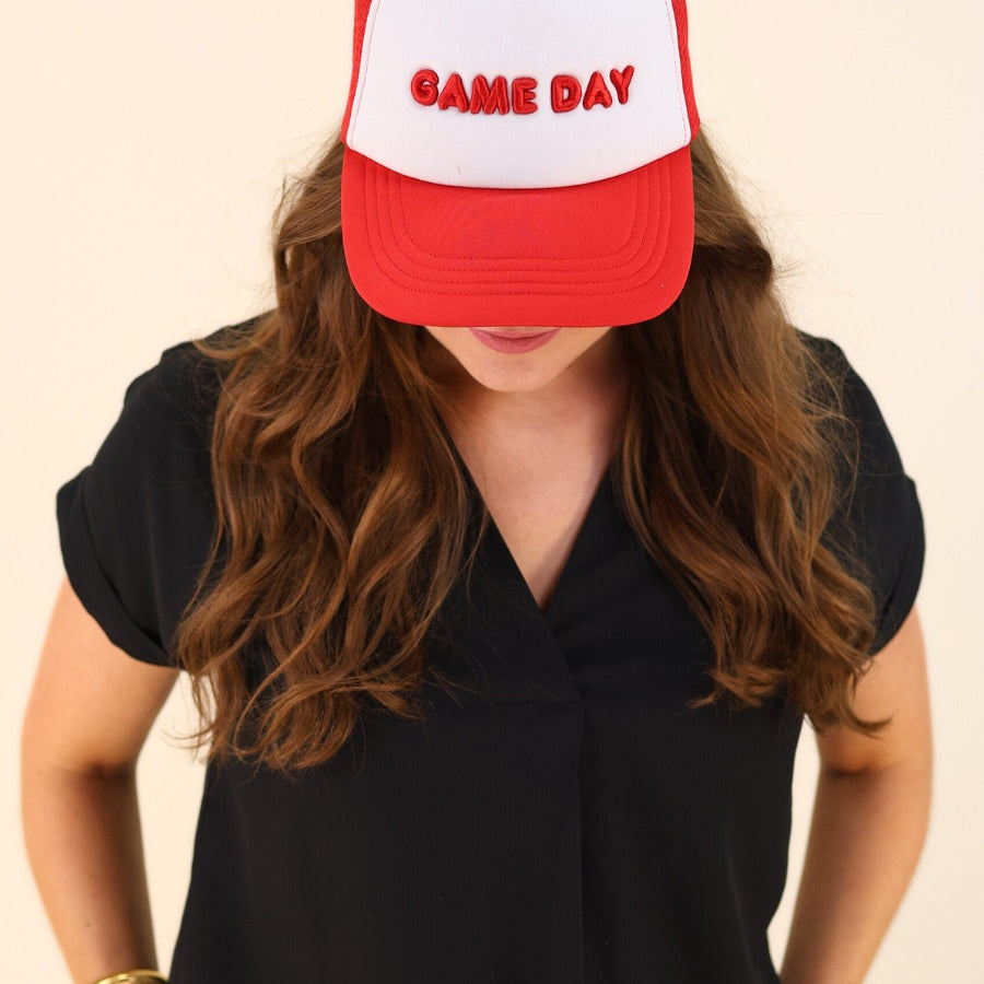a lightweight red two-tone trucker hat with raised embroidered 'GAME DAY' lettering, tall foam front panel, breathable mesh back, snapback closure, and a curved bill