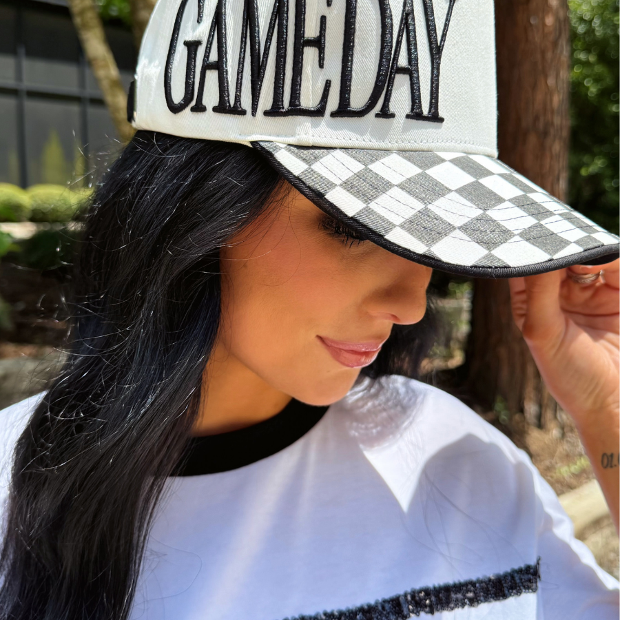 a neutral game day cap with bold embroidered lettering, a black-and-white checkered bill, contrast trim, and a sporty boutique-inspired design