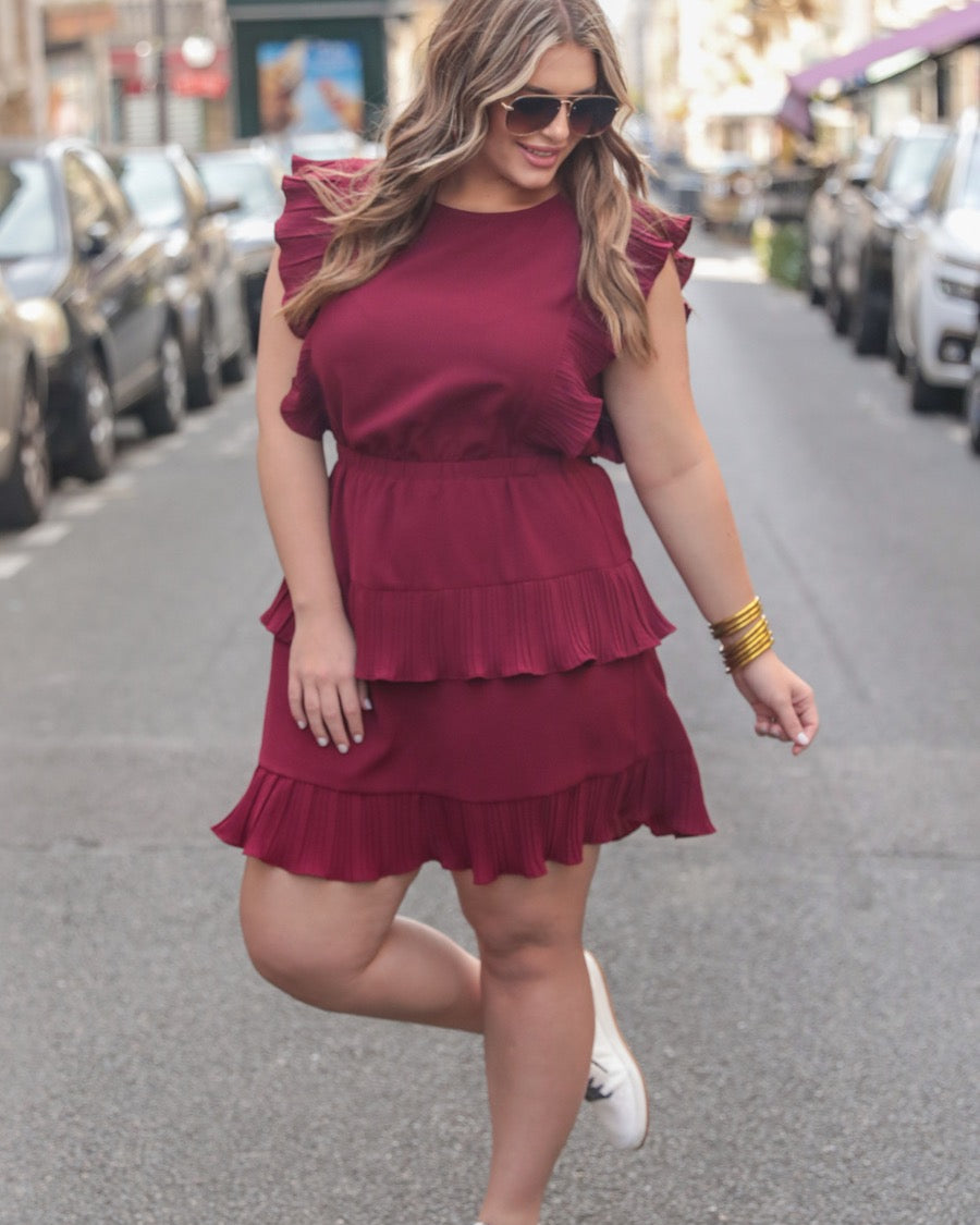 ruffled sleeve dress with layered pleats, an elastic waistband, and a lined bottom in burgundy