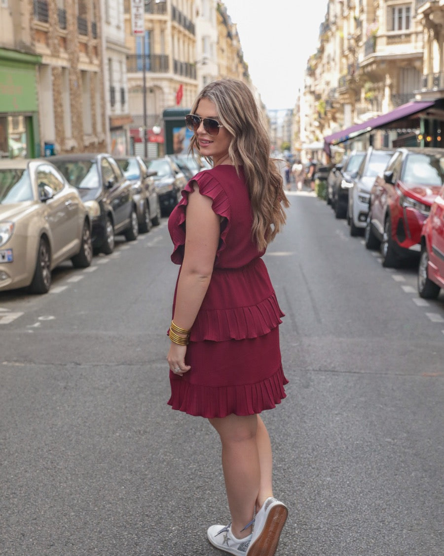 ruffled sleeve dress with layered pleats, an elastic waistband, and a lined bottom in burgundy