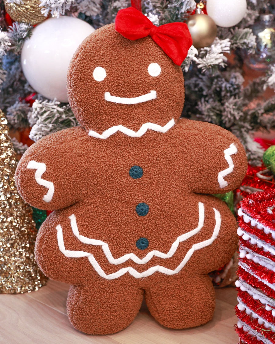 brown gingerbread girl fluffy pillow with dainty white icing details, stitched forest green buttons, and an adorable red bow