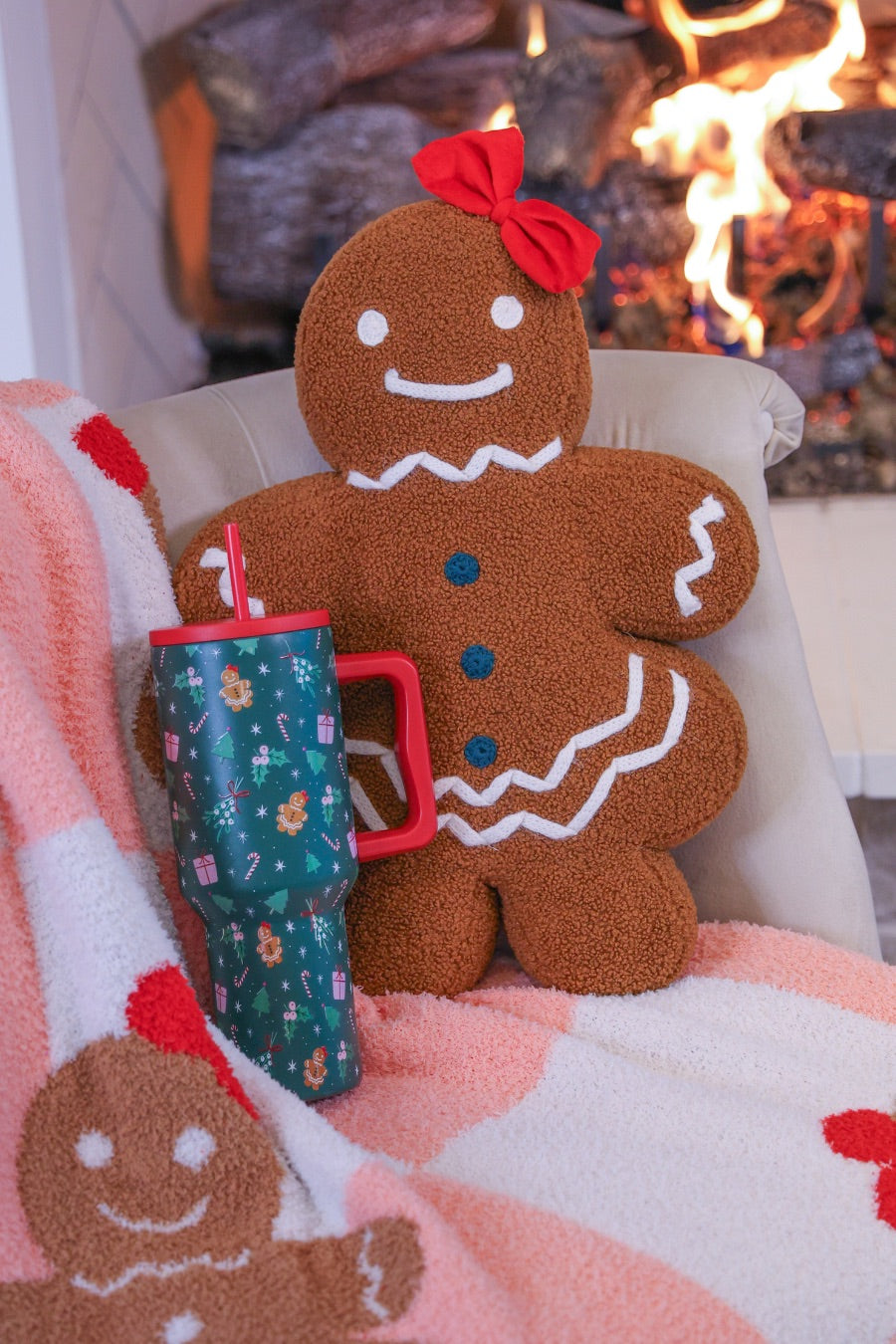 brown gingerbread girl fluffy pillow with dainty white icing details, stitched forest green buttons, and an adorable red bow with coordinating blanket and tumbler