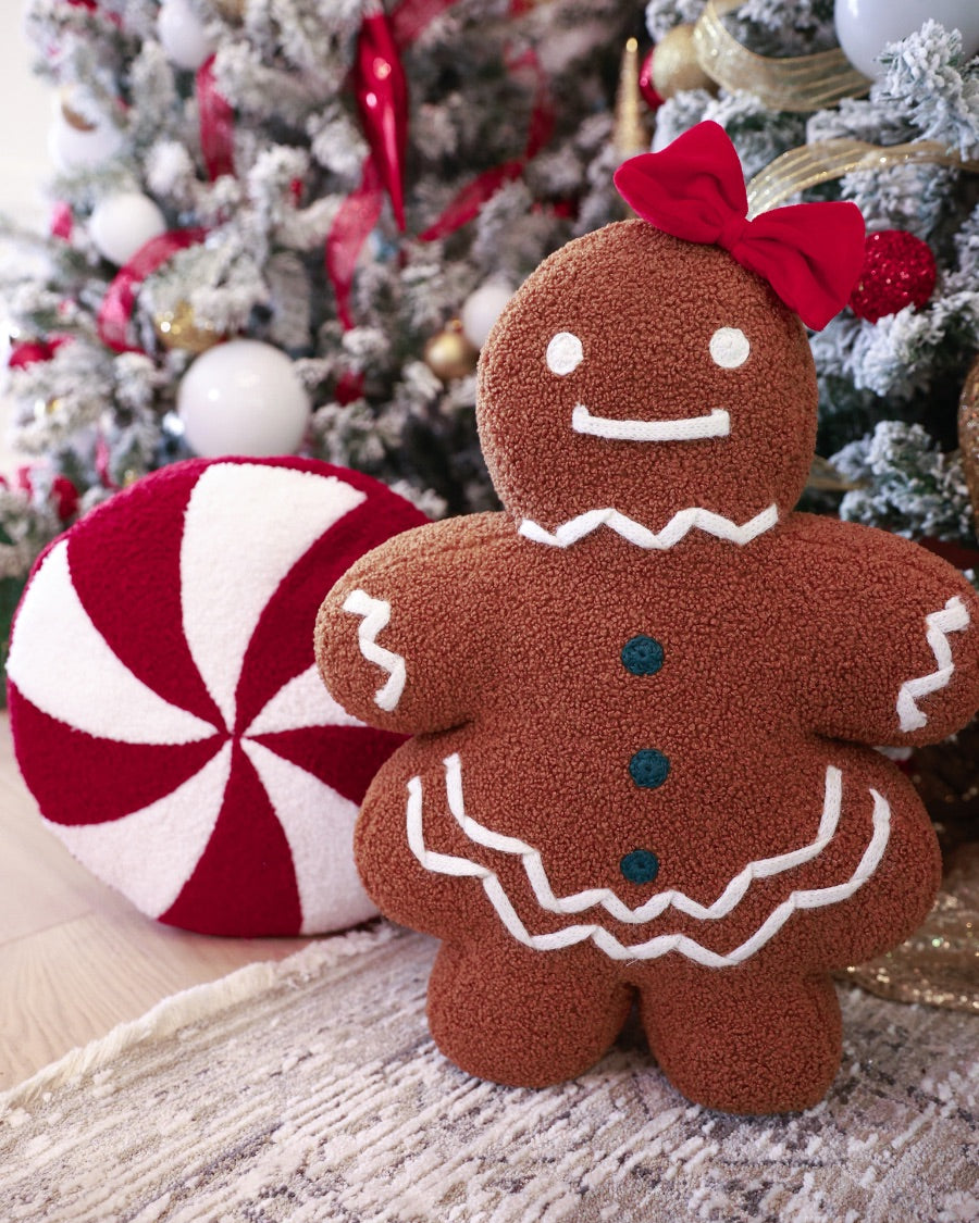 brown gingerbread girl fluffy pillow with dainty white icing details, stitched forest green buttons, and an adorable red bow paired with peppermint pillow