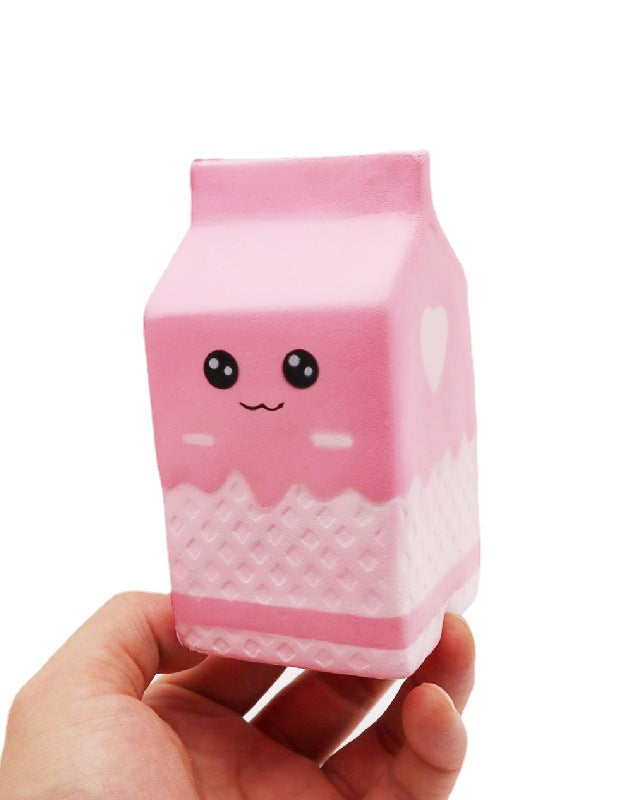 a pink milk-carton squishy with a kawaii face, pink-and-white colorblock design, textured accent panel, side heart detail, squeezable sensory feel, and clear individual packaging