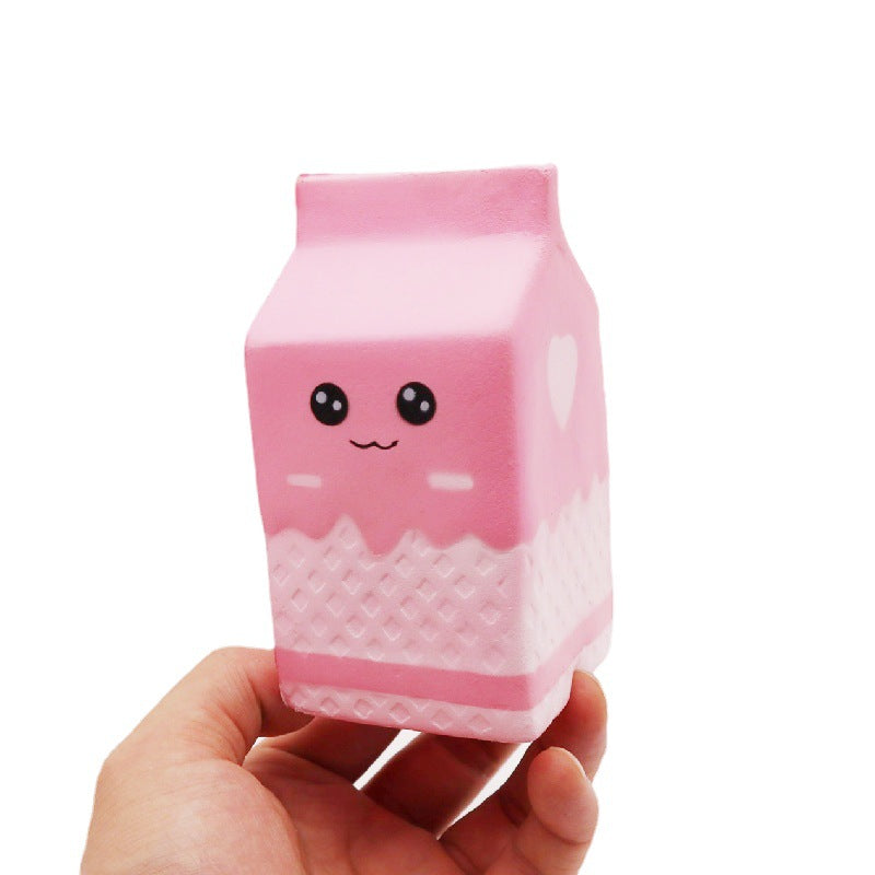 a pink milk-carton squishy with a kawaii face, pink-and-white colorblock design, textured accent panel, side heart detail, squeezable sensory feel, and clear individual packaging