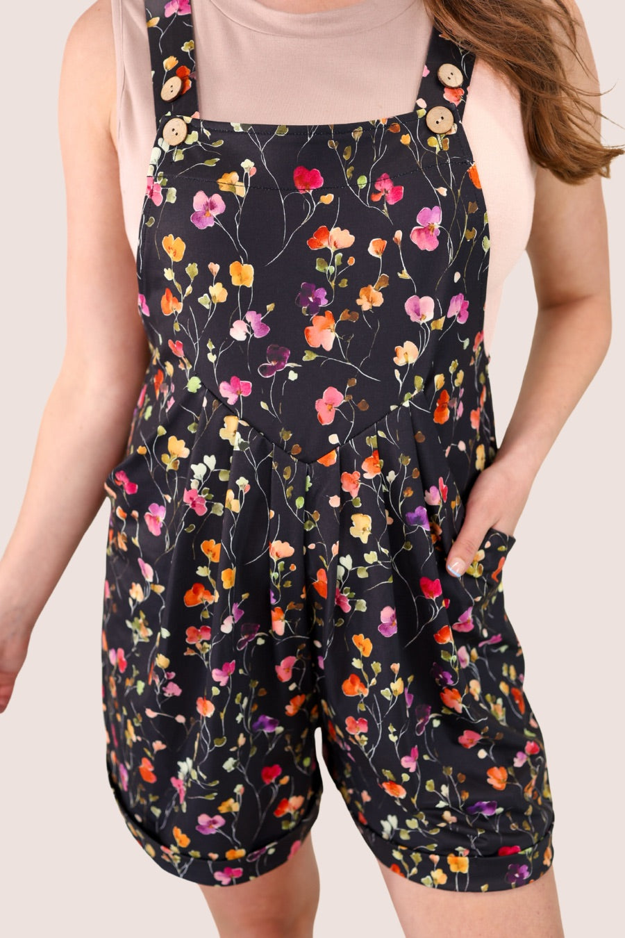 multicolor floral pattern print overall shorts on a black base made from our best-selling everyday fabric with functional button straps, a bib-style front, cuffed hems, roomy side pockets, and a relaxed silhouette