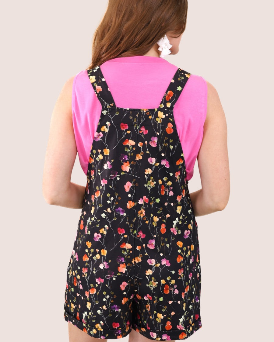 multicolor floral pattern print overall shorts on a black base made from our best-selling everyday fabric with functional button straps, cuffed hems, and side pockets