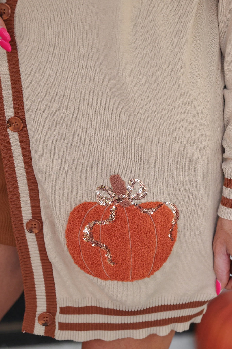 long-sleeve open front cardigan adorned with chenille pumpkins and sequin bows, functional pockets, and a relaxed fit in neutral