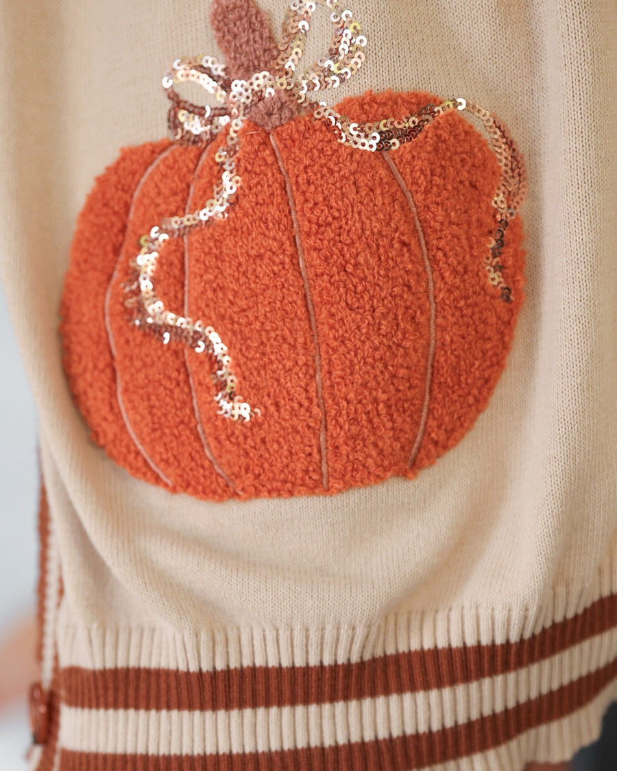 long-sleeve open front cardigan adorned with chenille pumpkins and sequin bows, functional pockets, and a relaxed fit in neutral