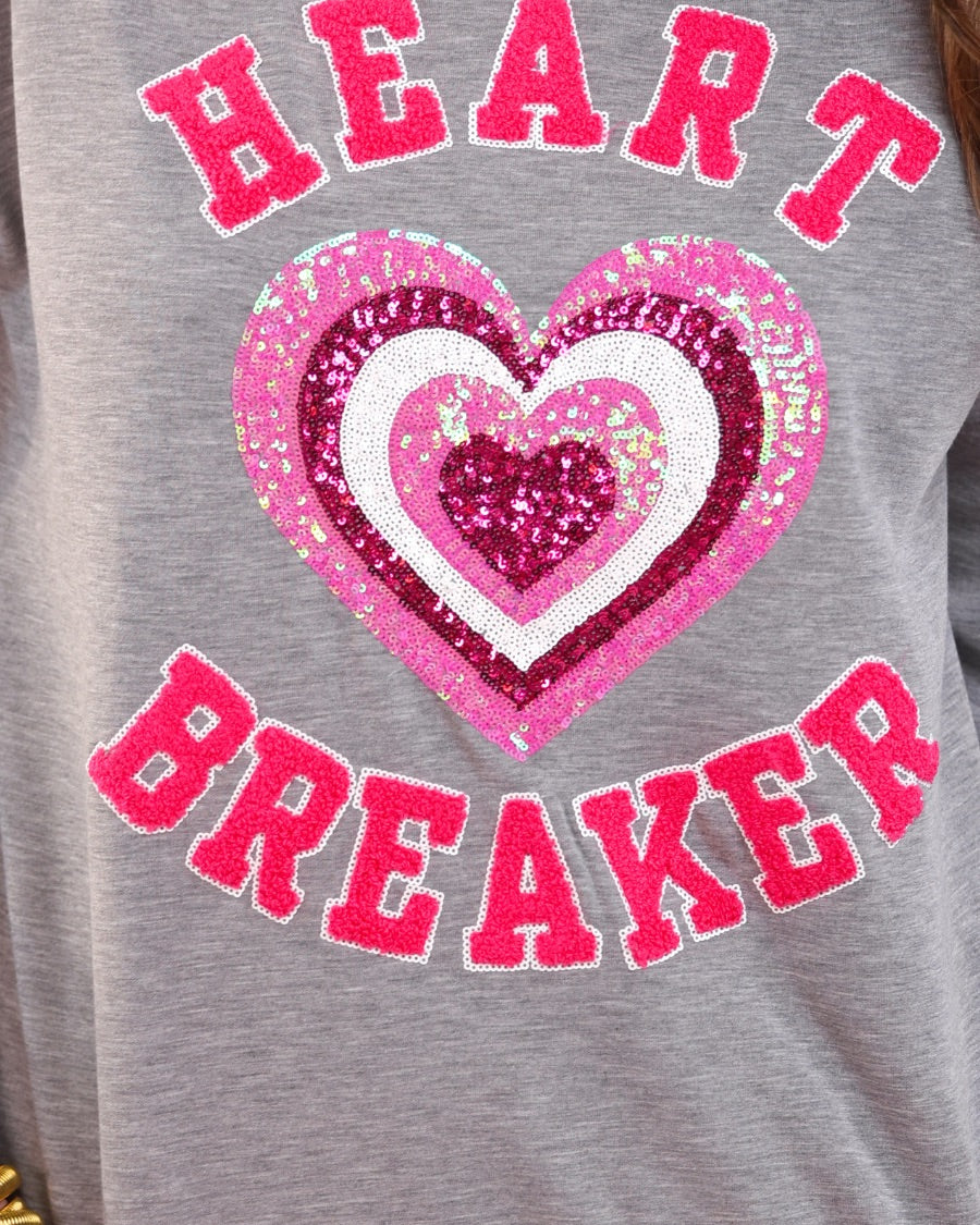 a gray long-sleeve pullover made from luxe material with chenille 'HEART BREAKER' lettering, a layered sequin heart detail, relaxed drop-shoulder fit, and ribbed neckline, cuffs, and hem for an effortlessly elevated look