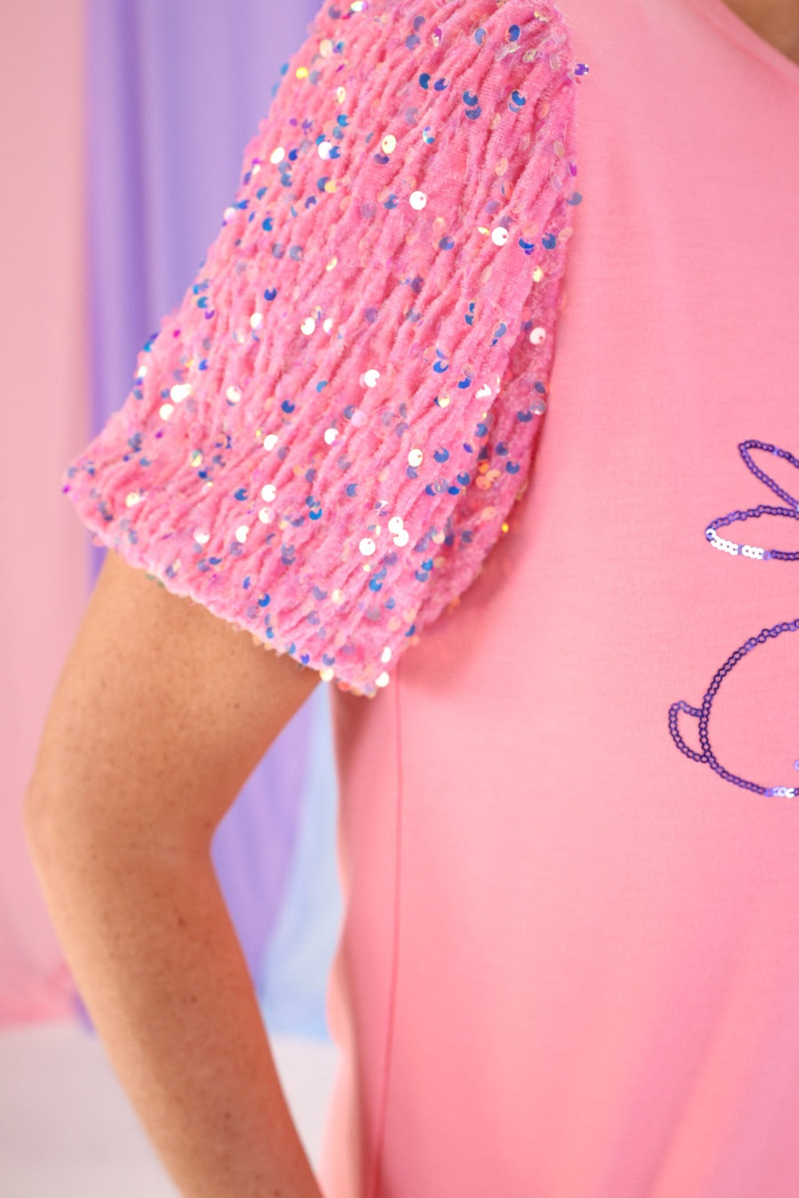 a soft velvet sequin sleeve top with four playful sequin bunny outlines on the front of a light pink fabric
