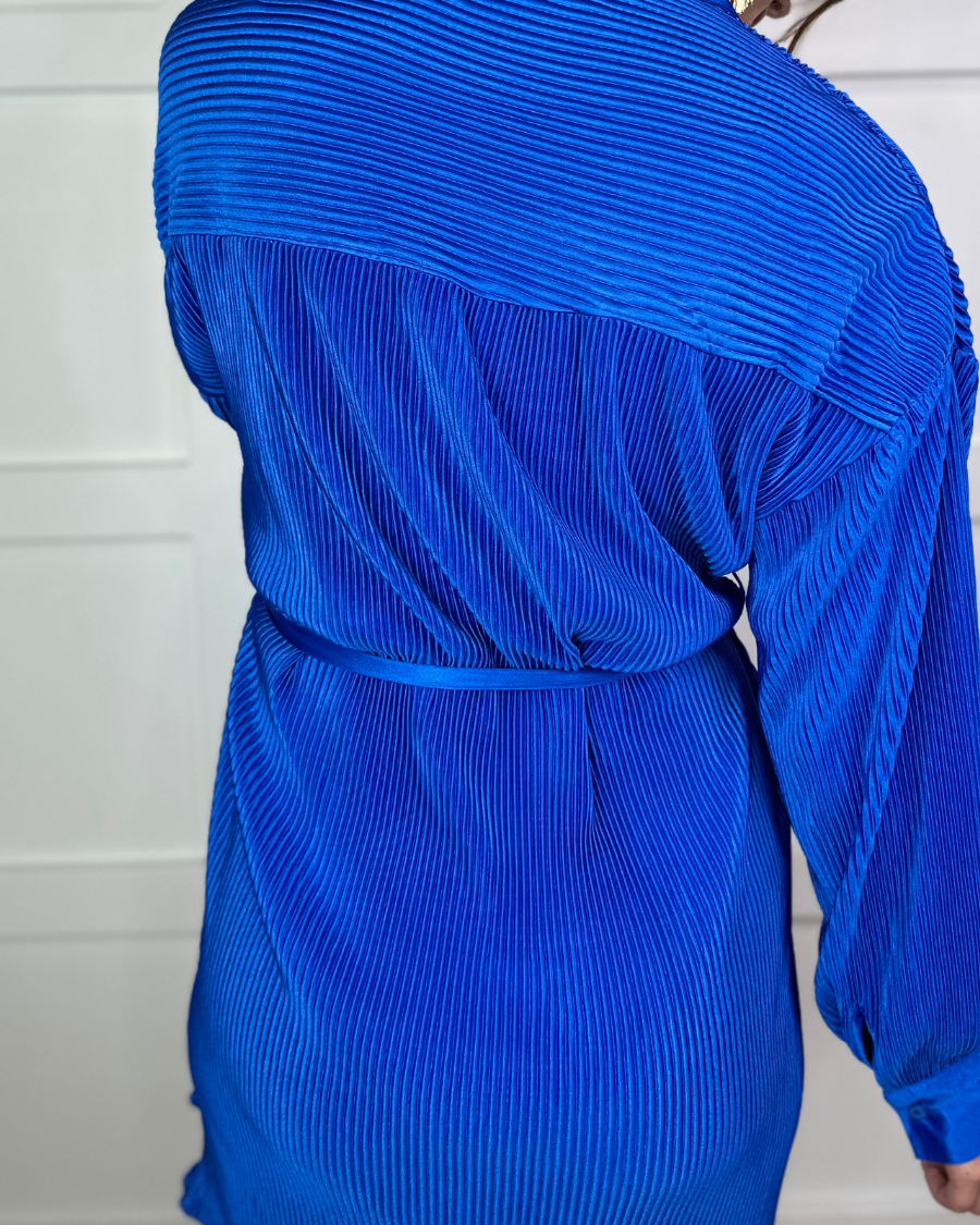 a royal blue pleated shirt dress with a classic collar, functional button front, removable waist sash, drop shoulder long sleeves, satin cuffs, back yoke seam, accordion texture, and flowy mini-length silhouette