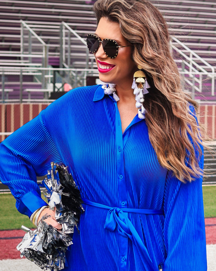 a royal blue pleated shirt dress with a classic collar, functional button front, removable waist sash, drop shoulder long sleeves, satin cuffs, back yoke seam, accordion texture, and flowy mini-length silhouette
