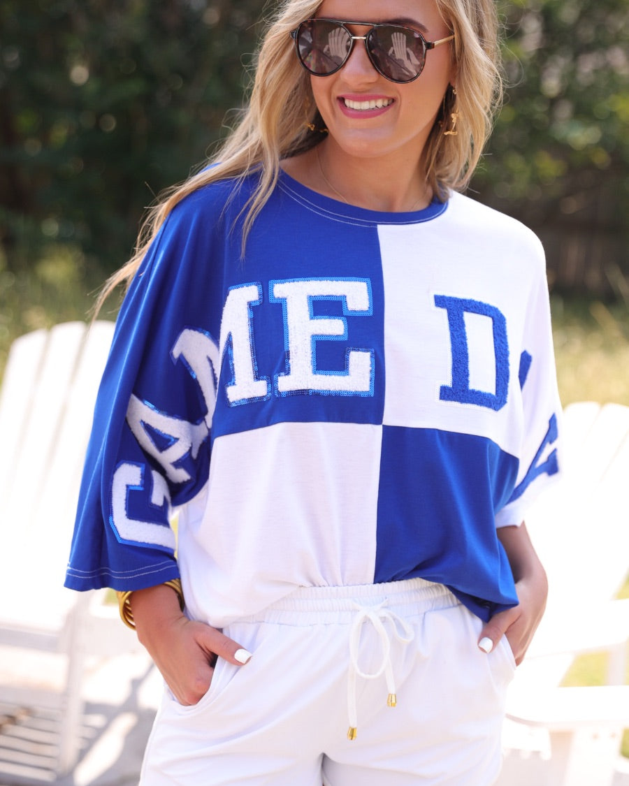 short-sleeve color block mom crop top with oversized chenille 'GAME DAY' lettering outlined in sequins, where GAME pops with a coordinating color outline to match the color block style, while DAY stands out with a crisp white outline in blue