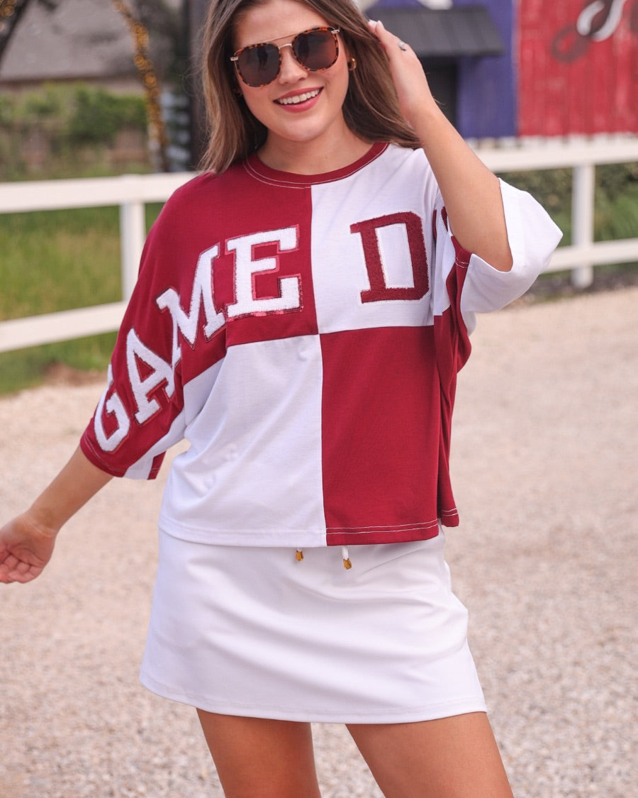 short-sleeve color block mom crop top with oversized chenille 'GAME DAY' lettering outlined in sequins, where GAME pops with a coordinating color outline to match the color block style, while DAY stands out with a crisp white outline in maroon