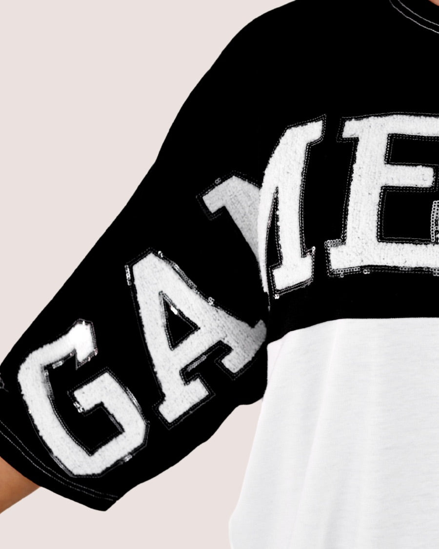 short-sleeve color block mom crop top with oversized chenille 'GAME DAY' lettering outlined in sequins, where GAME pops with a coordinating color outline to match the color block style, while DAY stands out with a crisp white outline in black