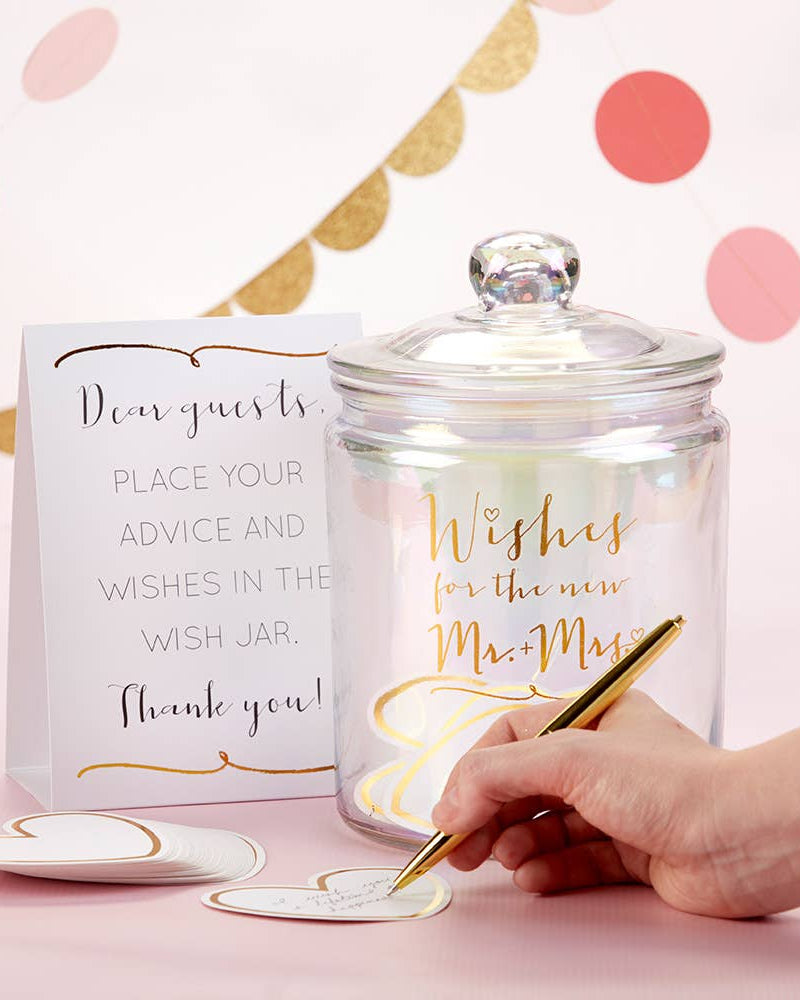 Wish jar with decorative text and a hand writing on a card against a polka dot background