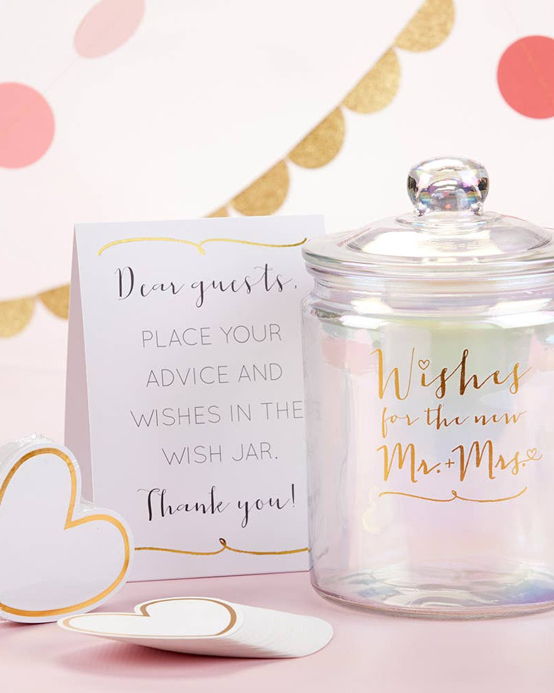 Glass wish jar with a decorative card on a pink background